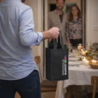 Person carrying a Cyprus Wine Tote Bags Double, joining friends at a candlelit dinner.