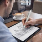 Someone sketches architecture on a tablet using Hector Stylus Pens in a cafe.