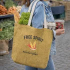 Person carrying Gemini Jute Shopping Bags with lettuce, bread, and strawberries inside.