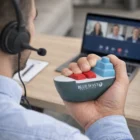 Person on video call squeezes a Cargo Ship Stress Ball labeled Blue Wave Shipping.