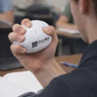 Person squeezing a Brain Stress Toy in a classroom.