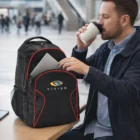 Man carrying coffee, placing laptop in black Venus Customised Laptop Bag at a public table.
