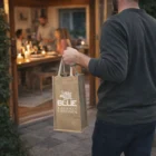 Person carrying Double Wine Carriers, heading to an indoor dinner gathering.