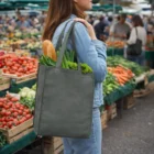 Woman with an Avis Tote Bag filled with produce at a farmers market.