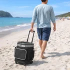 Man pulling a Yara Cooler Trolley on a sandy beach by the ocean.
