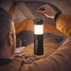 Camper holds a Lumen Flashlight Lantern inside a tent while camping.