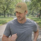 Man jogging in a park wearing Denim Logo Branded Fashion Caps and a grey t-shirt on a sunny day.