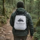 Hiker in forest with a Crystal Drawstring Backpack from Seamount Financial Group.