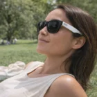 Woman in Reef Sunglasses relaxing on grass at the park on a sunny day.