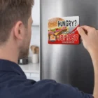 Man placing a Rectangle Fridge Magnet 9 X 8Cm on a stainless steel refrigerator.