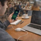 Charging a smartphone with Powerwire Charging Cables at a café, notebook and coffee nearby.