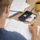 Student at desk with books, coffee, and a Cytron Wireless Charging Hubs.