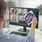 Man on video call holding Mix & Match card and Dual Action Promotional Cleaning Cloths by computer.