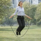 Woman in business attire jumps rope with Classic Wooden Skipping Ropes in a city park.