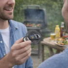 Two men at a barbecue, one holding a Fidget Spinner Bottle Opener. Grill in background.