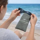 Someone grabs sunglasses from a Flexo Sunglasses Pouch at Holiday Villa Hotel & Suites beach.
