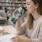 Woman enjoys Premium Vacuum Cup while writing in her notebook at the library table.