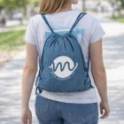 Woman carrying books with Denim Look Drawstring Bag outdoors on a sunny day.
