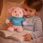 Child in pajamas reads, hugging a Pig Customised Plush Toy dressed in your logo T-shirt.