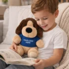 Smiling boy reads with Dog Customised Plush Toy in a shirt printed with YOUR LOGO HERE.