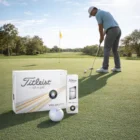 A golfer putts on the green with Titleist Velocity Golf Balls in front.