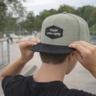 Someone wearing an Ander Flat Peak With Patches cap at a skate park.