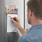 Man writing Milk on a Personalised House Shape Pad - A7 attached to fridge with a magnet clip.
