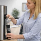 Woman filling a 300Ml Skinny Metal Bottle at an office water dispenser.