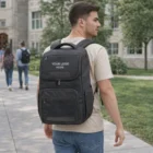 Man with Swiss Peak Voyager Laptop Backpack featuring your logo, walking on a campus walkway.