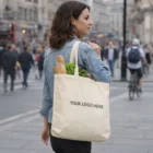 Woman with Hinckley Cotton Tote Bag, YOUR LOGO HERE, walking on a city street.