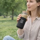 Woman sipping iced coffee from Sleek Glass Tumblers in a park.