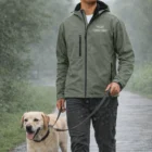 Person walking a Labrador in the rain, wearing a Sols Replay Mens Softshell Jacket.
