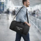 Smiling man at airport carrying Glengarry Duffle Bags with YOUR LOGO HERE printed on them.