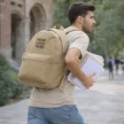 Man carrying Brookline Canvas Backpack with notebooks outdoors. Add your logo!.