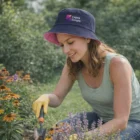 Woman gardening in Brentwood wearing Brentwood Reversible Bucket Hat among flowers.