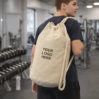 Teen boy in gym carrying a beige Raven Canvas Barrel Bag with custom logo printed on it.