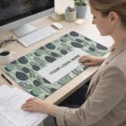 Woman at desk uses Lauderdale Desk Mats leafy mouse pad labeled Your Logo Here by computer.