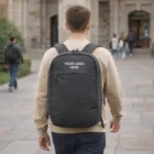 Man with an Osprey Arcane Large Day Backpack walks on stone path near a building.