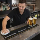 Bartender cleans bar near two beers; Minette Bar Runners Large display YOUR LOGO HERE.