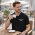 Smiling man in Sols Planet Mens Polos with custom logo, holding coffee at outdoor café.