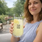 Woman smiling outdoors, holding a Luigi Bormioli Optica Hi Balls glass with YOUR LOGO HERE.