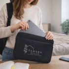 Woman inserts tablet into a Large Neoprene Device Sleeve by a notebook.