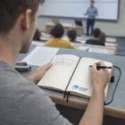 Student uses Hard Kraft Cover Notebooks for note-taking during a lecture.