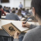A student uses a Paper Spiral Notebook while taking notes in class.