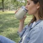 Woman enjoys a sunny park, sipping from a 300Ml Vacuum Cups.