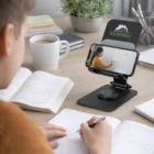 Someone watches a math lesson on their phone using Metal Phone Stands and takes notes.