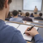 Student taking notes with a Matte Black Ct Ballpoint Parker Sonnet metal pen during a lecture.