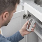 Greenville Multi Tools used to tighten a cabinet door hinge screw.