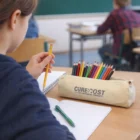 Student writing with Hale Tutor Pencils Cases on the desk.