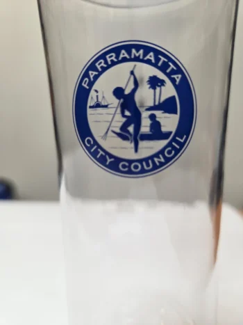 Clear glass event item with Parramatta City Council logo featuring a person with a spear and trees.